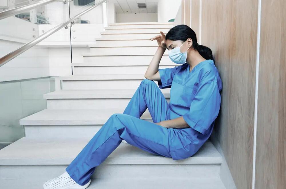 magen de un profesional sanitario en un hospital reflejando agotamiento físico y emocional, representando el impacto del burnout en el sector sanitario.
